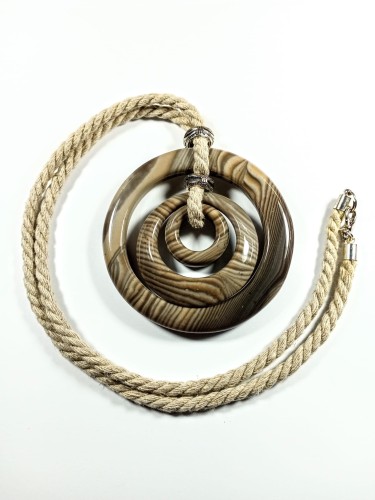 Krzemień pasiasty potrójne pawie oczko na naturalnym 
sznurku ekru 
Rozmiar kamienia 7cm, długość sznurka ok. 60cm