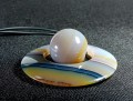 Wisiorek Agat donut z kulką.
Wielkość kamienia 6,8 cm.
W komplecie syntetyczny rzemień czarny o długości 70cm