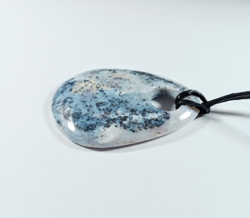 Chalcedon z otworkiem na naturalnym, czarnym rzemieniu
Rozmiary kamienia 55mm x 40mm.