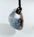 Chalcedon z otworkiem na naturalnym, czarnym rzemieniu
Rozmiary kamienia 55mm x 40mm.